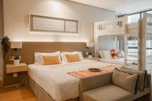 a bedroom with a large bed and a chair at 188 Suites by KidsCastle in Kuala Lumpur