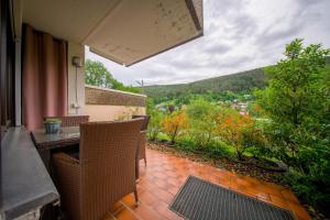 ein Balkon mit Tisch und Stühlen und Aussicht in der Unterkunft Kurpark Apartment, Schwimmbad, Sauna, Terrasse in Bad Wildbad