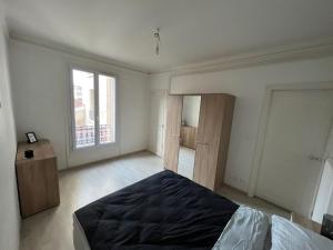 una camera da letto con un letto grande e una finestra di Grand T3 avec parking privé, centre & caves à champagne a Reims