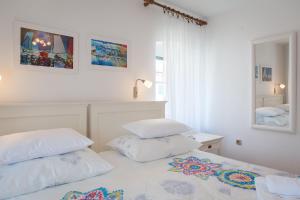 a white bedroom with two pillows on a bed at Apartments Sunce in Split
