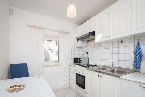 Una cocina blanca con fregadero y microondas. en Apartments Sunce, en Split