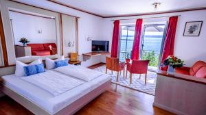 a bedroom with a large bed and a living room at Seehotel ZUR MÜNZ in Meersburg