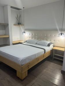a large bed in a bedroom with two pendant lights at Hotel 42 Avenida in Palmira