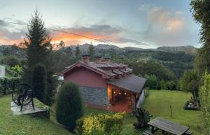 una pequeña casa en un campo con una puesta de sol en Apartamentos Flordelinto, en La Cárcoba