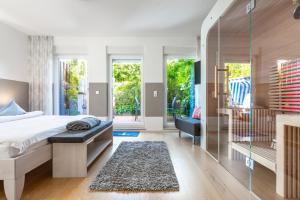 Un dormitorio con una cama y una puerta corrediza de vidrio. en Deichperle mit bemberg airSPACE Sauna, en Juist