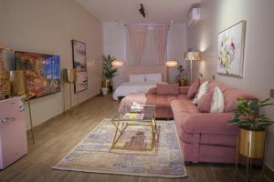sala de estar con sofá rosa y cama en Nairah Residence, en Riad