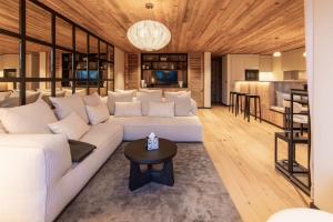 a living room with a white couch and a table at Antarès ORION 202 - luxury apartment ski inski out in Méribel
