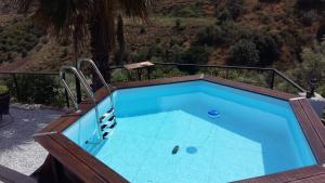 a lap pool with a wooden deck and blue water at Cortijo A Navas in Frigiliana