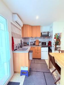 a small kitchen with wooden cabinets and a table at Le Moorea - Apartment for 4 people in Hyères