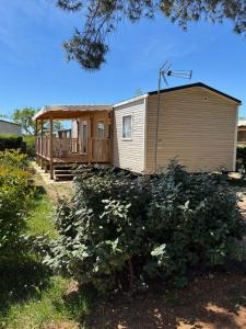 a small house with a porch and a deck at Mobil-home Evasion et confort in Lattes