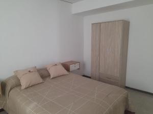 een slaapkamer met een bed en een houten kast bij Complejo Vélez Sarsfield 185 in Bell Ville +3 foto's