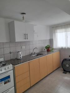 een keuken met een spoelbak en een fornuis bij Complejo Vélez Sarsfield 185 in Bell Ville