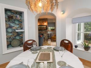 a dining room with a white table and chairs at Rookery Cottage in Lynton