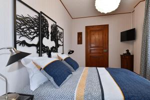 a bedroom with a large bed with blue and white pillows at Le BERG'KAY in Kaysersberg