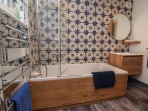 a bathroom with a tub and a shower at Rookery Cottage in Lynton +32 photos