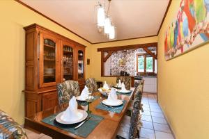 a dining room with a wooden table and chairs at Le BERG'KAY in Kaysersberg