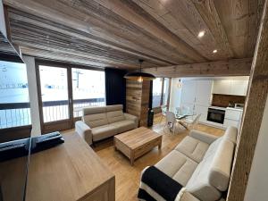 a living room with a couch and a table at Appartement standing -spa wellness sur les pistes in Tignes