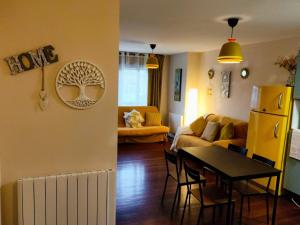 a living room with a table and a yellow refrigerator at Don Divino in Medina de Pomar