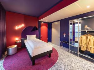 a bedroom with a bed and a dressing room at ibis Styles Muenchen Perlach in Munich +76 photos