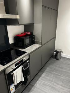 a kitchen with a stove and a microwave at Stunning apartment with parking near Barnsley town centre sleeps 4 in Barnsley +4 photos