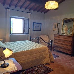 a bedroom with a bed and a dresser and a window at Casa Vacanze Il Fornacino in Asciano