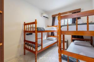 a room with three bunk beds in a house at Apto c/ varanda e churrasq. a 290m do mar CAU0199 in Meia Praia