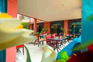 a restaurant with tables and chairs in a building at Hôtel La Villa Racine in Dakar