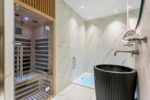 bagno con doccia e vasca nera di L'Exclusif Spa Suites Prestige Lyon Croix-Rousse a Lione