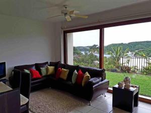 a living room with a couch and a large window at Departamento Cruz de Mar in Santa Maria Huatulco