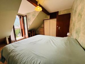 a bedroom with a large white bed with a window at Chez Vincent Duplex 70 m2 3 ch Hypercentre in Luchon