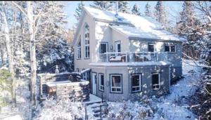 a large house with snow on the ground at La Renardière des Monts in Les Éboulements