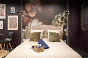 una camera da letto con un letto e un dipinto sul muro di Deluxe Studio, Dark Floral, jacuzzi, Parking Gratuit, MULHOUSE CENTRE a Mulhouse