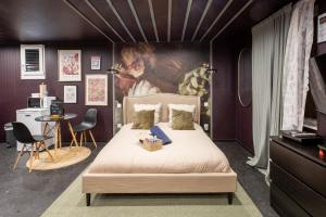 una camera da letto con un letto e un dipinto sul muro di Deluxe Studio, Dark Floral, jacuzzi, Parking Gratuit, MULHOUSE CENTRE a Mulhouse