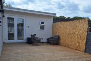 a patio with chairs and a table and a fence at Lodge - Sleeps 2 - Pet friendly - Parking - Patio in Sidcup