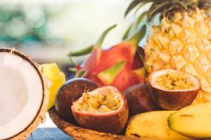 a bowl of fruit with a pineapple and bananas at "Lagon Bleu" Duplex lumineux à St Gilles les Bains in Saint-Paul