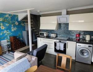 a kitchen and living room with a couch and a table at Jolly Fox Folkestone in Folkestone