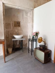 une salle de bains avec un lavabo et une télévision au sol dans l'établissement Barrio Sureño Hotel Boutique, à Arequipa