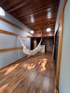 a hammock in a room with a wooden ceiling at House Amorim 13 min Parque peão in Barretos