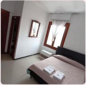 a bedroom with a bed and two windows at Hotel clásico in Manizales