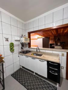 a kitchen with a sink and a counter top at House Amorim 13 min Parque peão in Barretos