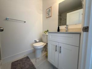 a bathroom with a toilet and a sink and a mirror at Luxury apartment at excellent location, Breakfast and Parking in Miami