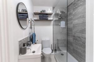a bathroom with a toilet and a sink and a mirror at Luxury 1 Bed Apartment Bromley in Bickley