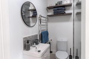 a white bathroom with a sink and a mirror at Luxury 1 Bed Apartment Bromley in Bickley +16 photos