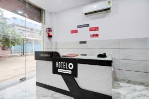 a hotel counter with a sign on a wall at Hotel O Rohini Sector 21 Shelter Inn in New Delhi