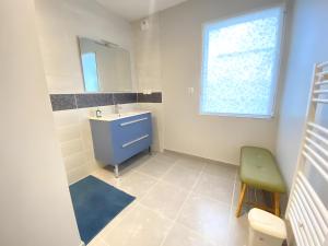 a bathroom with a blue sink and a window at Ty Cath - Maison en bord de mer in Guissény