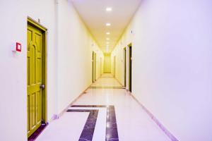 an empty hallway with yellow doors and a tile floor at Hotel O Howrah Botanical Garden in Kolkata +16 photos