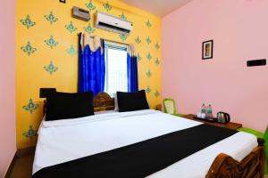 a bedroom with a large bed with blue and yellow walls at Collection O Sarvodaya Nagar Near Railway Station in Puri