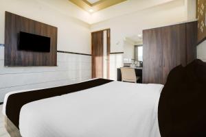 a bedroom with a white bed and a television at Collection O Mumbai-Ahmedabad Highway in Mumbai