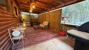 a screened in porch with a couch and a chair at Ruimyz cabbin in Manot