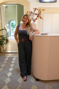 Eine Frau steht neben einem Tresen in der Unterkunft xenia apartments & suite in Syrakus